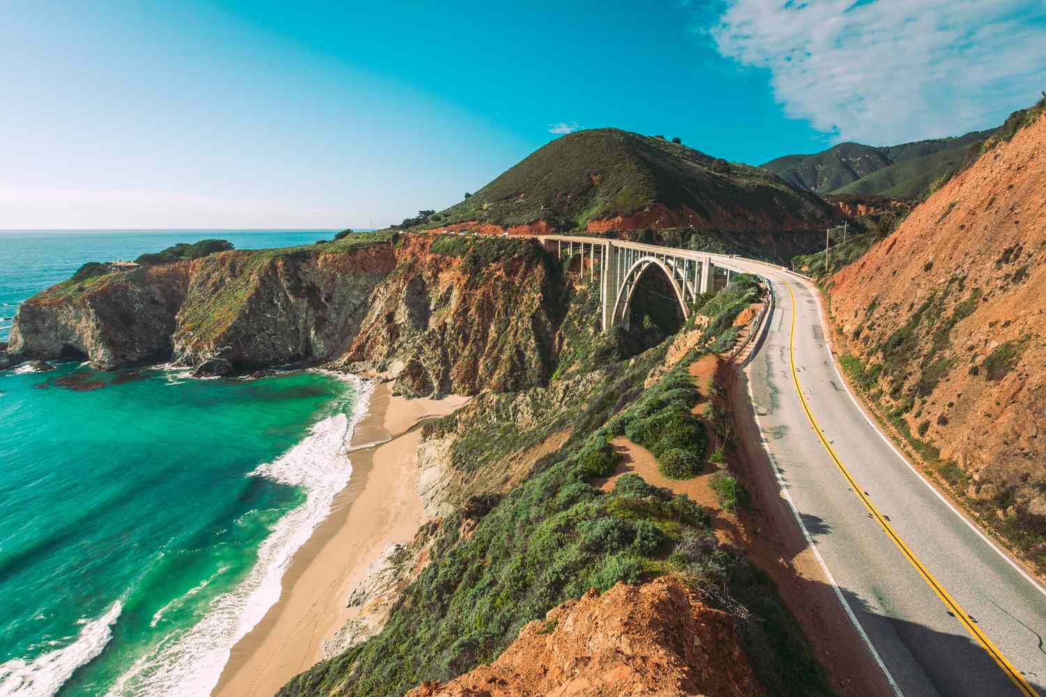 Highway 1 winding above turquoise water and cliffs on the California Coast